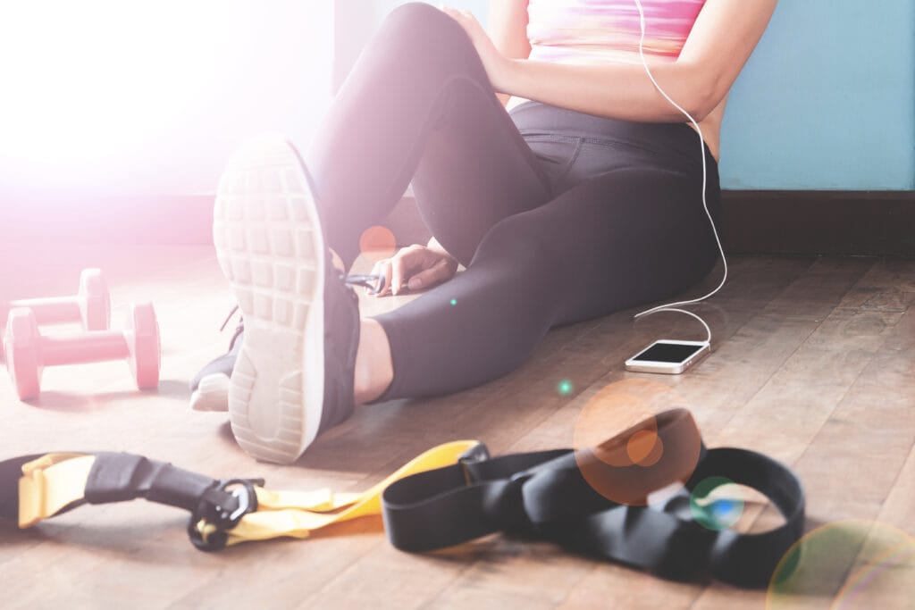 Female fitness resting and relaxing after workout. Woman sitting down on wood floor. Sport, Fitness, Healthy lifestyle concept female-fitness-resting