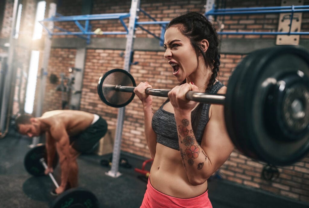 Fit couple lifting barbells in the gym EatFailGrow